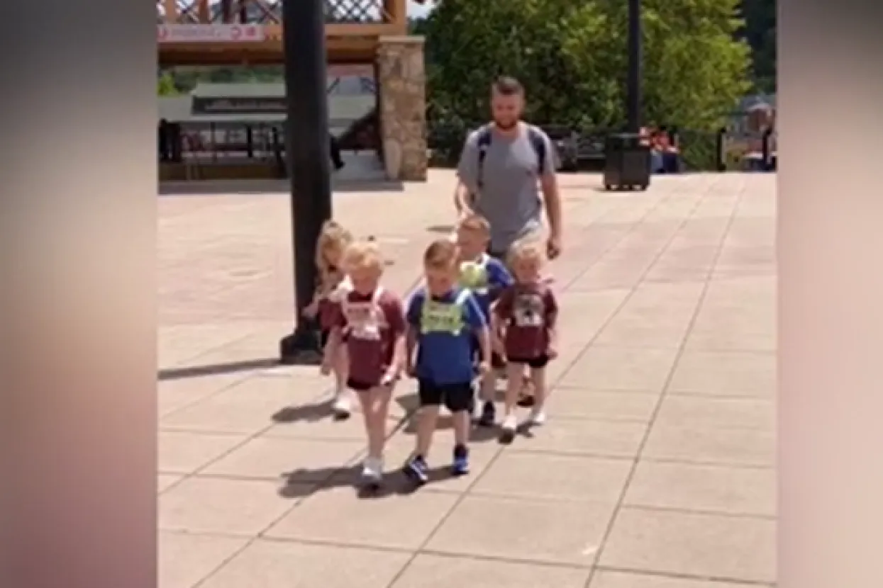 Otac vodi djecu na povodcu