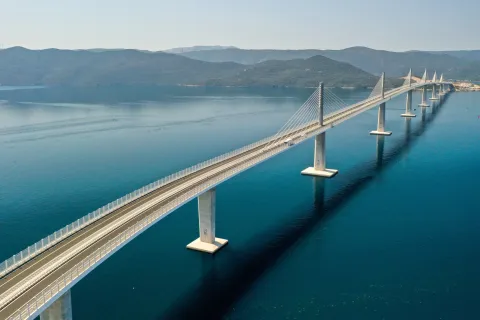 Komarna, 26.07.2022 - Pelje&scaron;ki most dužine 2404 metara koji spaja južni dio Hrvatske sa ostatkom domovine snimljen iz zraka. Na slici Pelje&scaron;ki most, most, tabla, građevina, ilustracija.