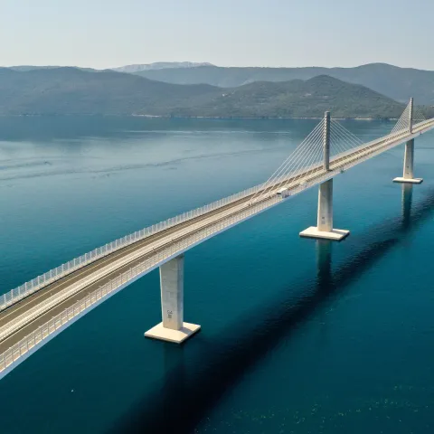 Komarna, 26.07.2022 - Pelje&scaron;ki most dužine 2404 metara koji spaja južni dio Hrvatske sa ostatkom domovine snimljen iz zraka. Na slici Pelje&scaron;ki most, most, tabla, građevina, ilustracija.